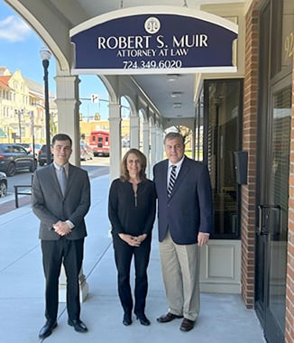 The team at Robert S. Muir, Attorney at Law in front of their Indiana office